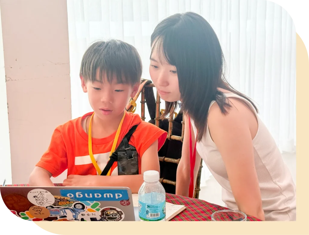 メンターが子供に寄り添って教えている画像
